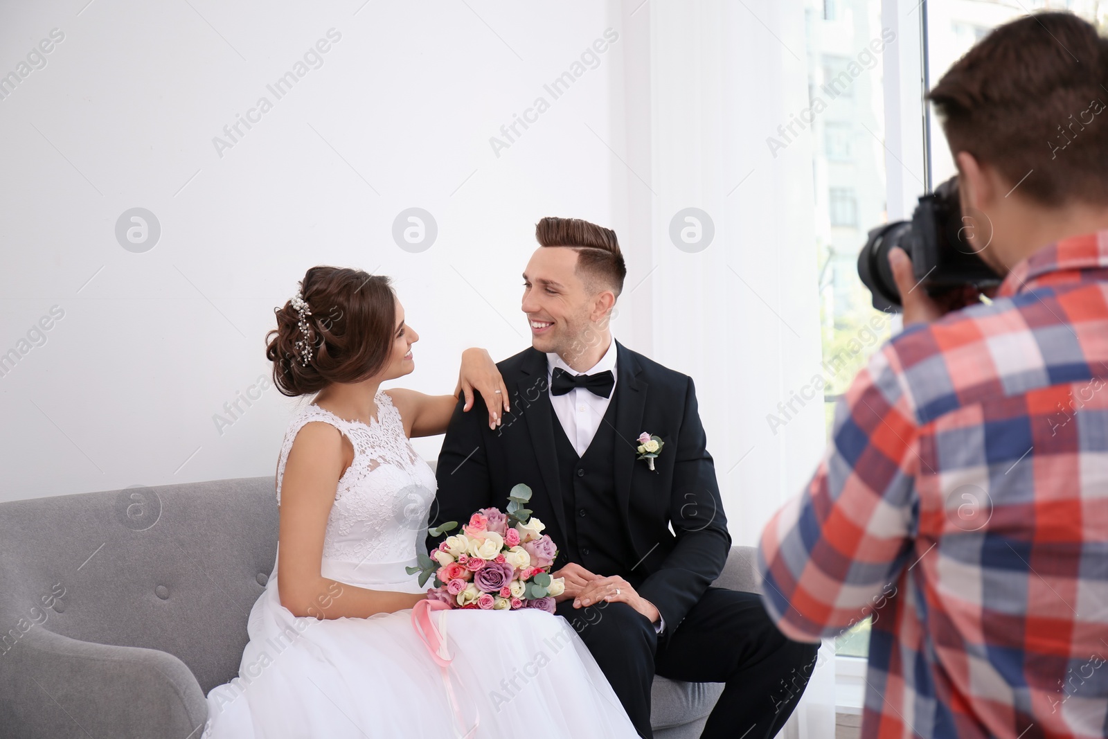 Photo of Professional photographer taking photo of wedding couple in studio