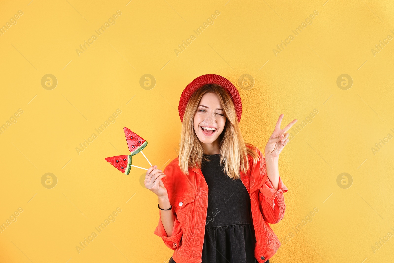 Photo of Young pretty woman with candies on colorful background