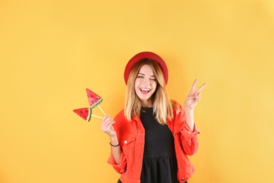 Young pretty woman with candies on colorful background