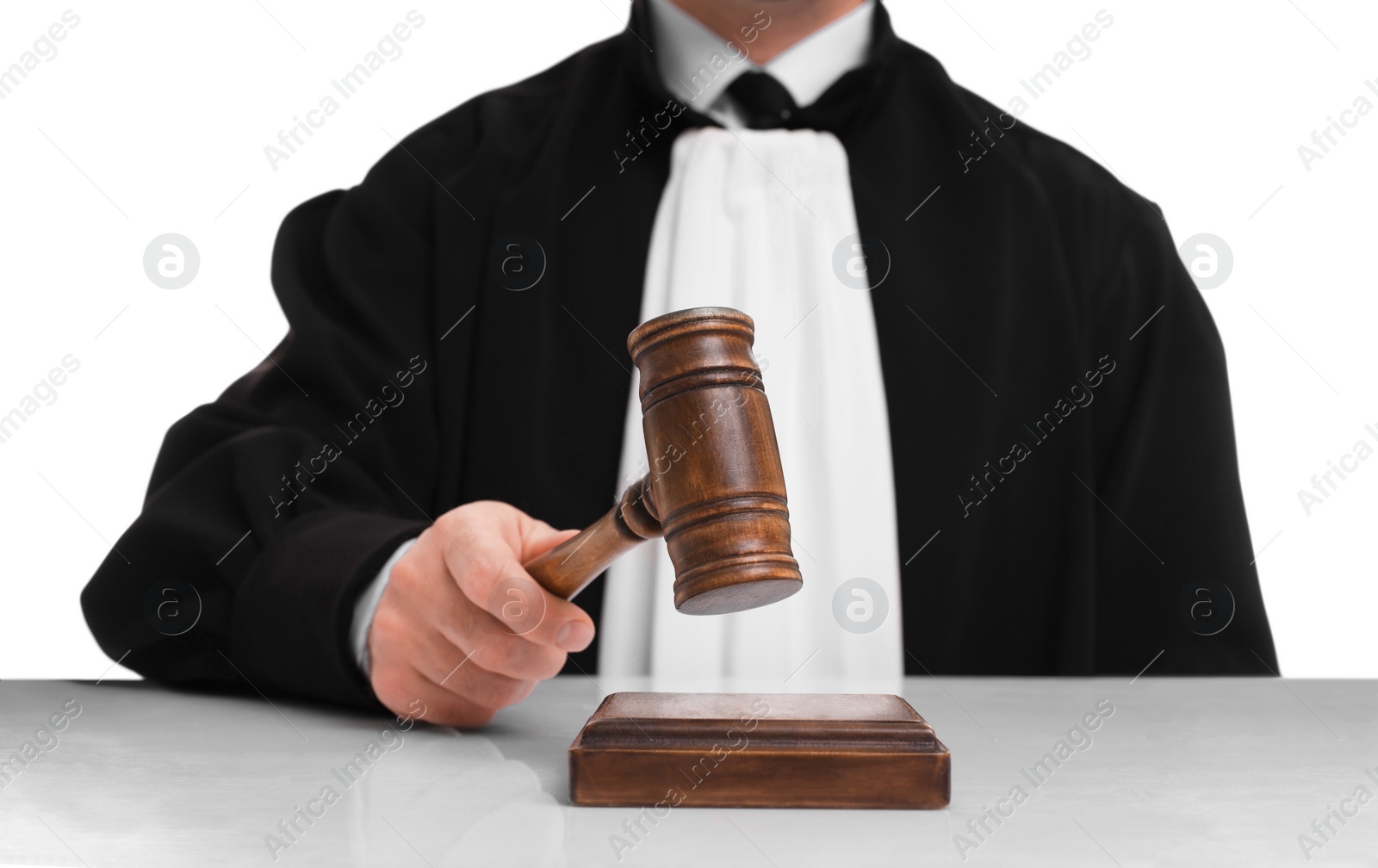 Photo of Judge with gavel at table on white background, closeup