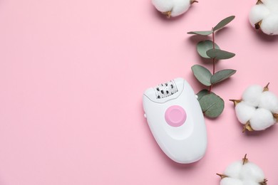 Modern epilator, fluffy cotton flowers and eucalyptus branch on pink background, flat lay. Space for text