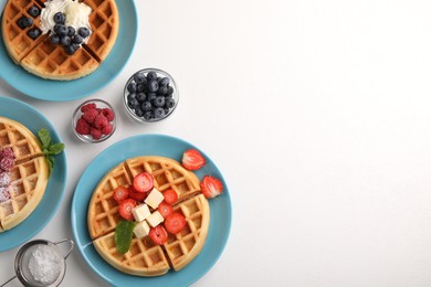 Tasty Belgian waffles with fresh berries served on white table, flat lay. Space for text