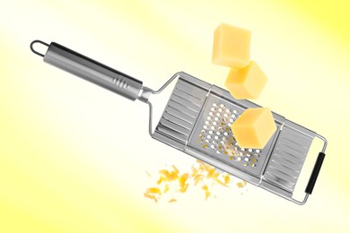 Image of Grating cheese with hand grater on yellow background