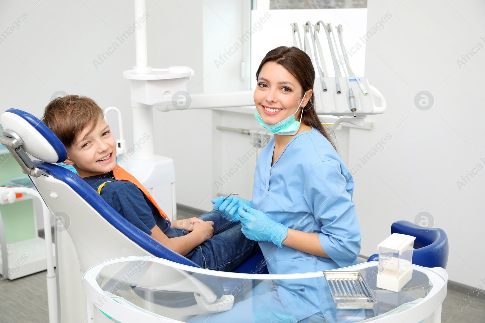 Photo of Professional dentist and little boy in clinic