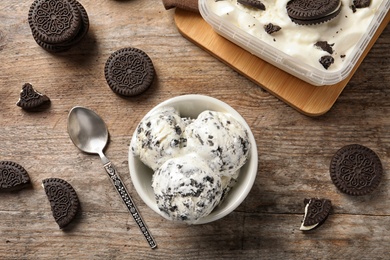 Photo of Flat lay composition with bowl of chocolate cookies ice cream on wooden background
