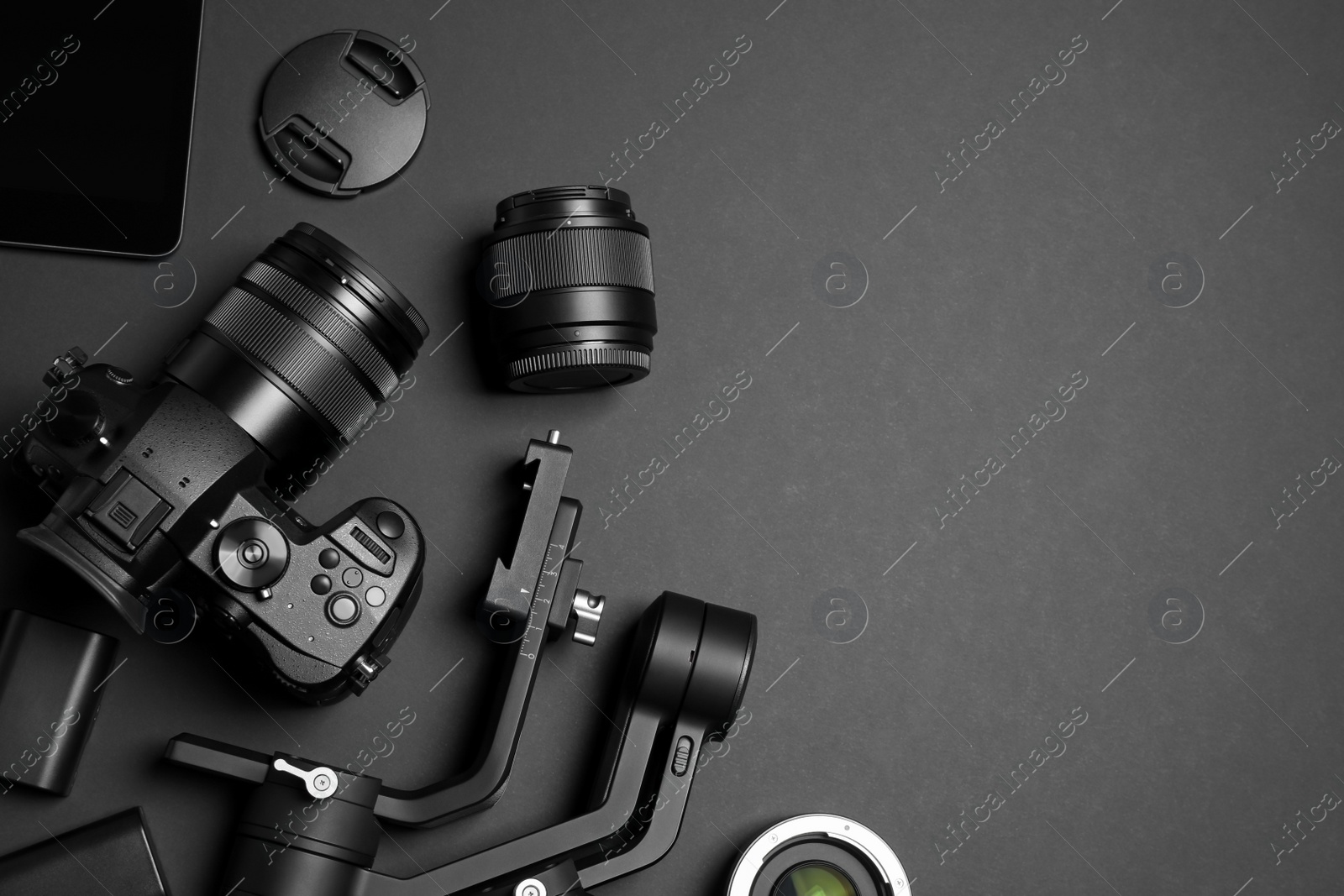 Photo of Flat lay composition with camera and video production equipment on black background. Space for text