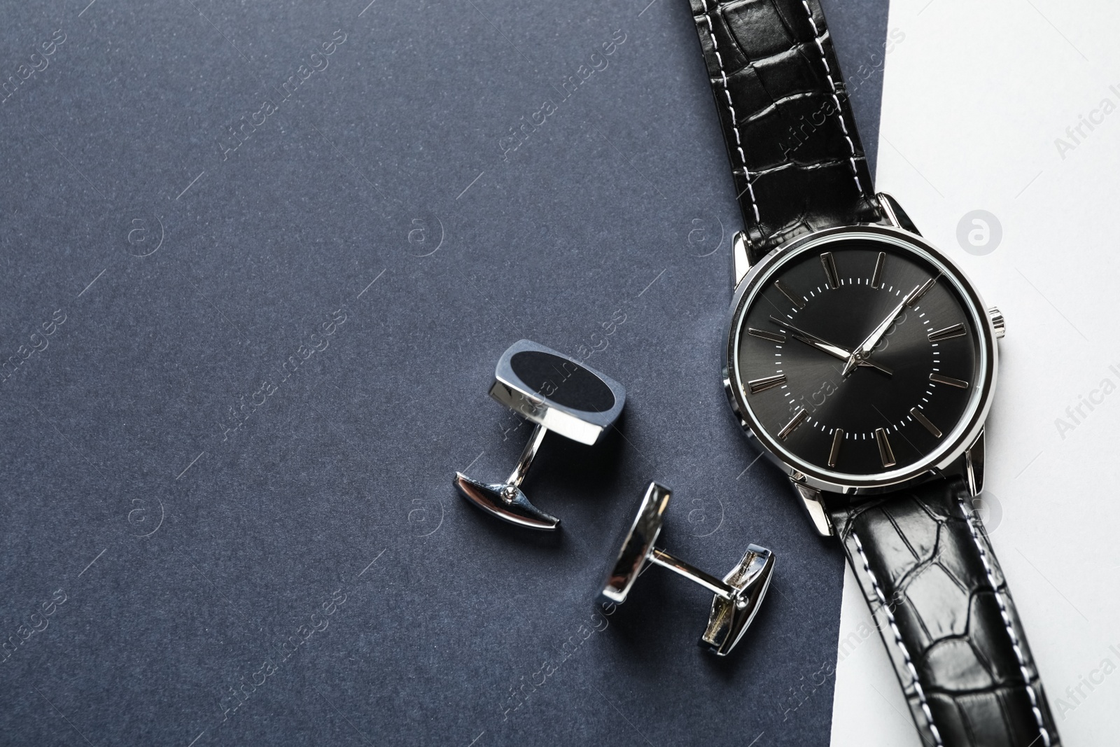 Photo of Luxury wrist watch and cufflinks on color background, flat lay. Space for text