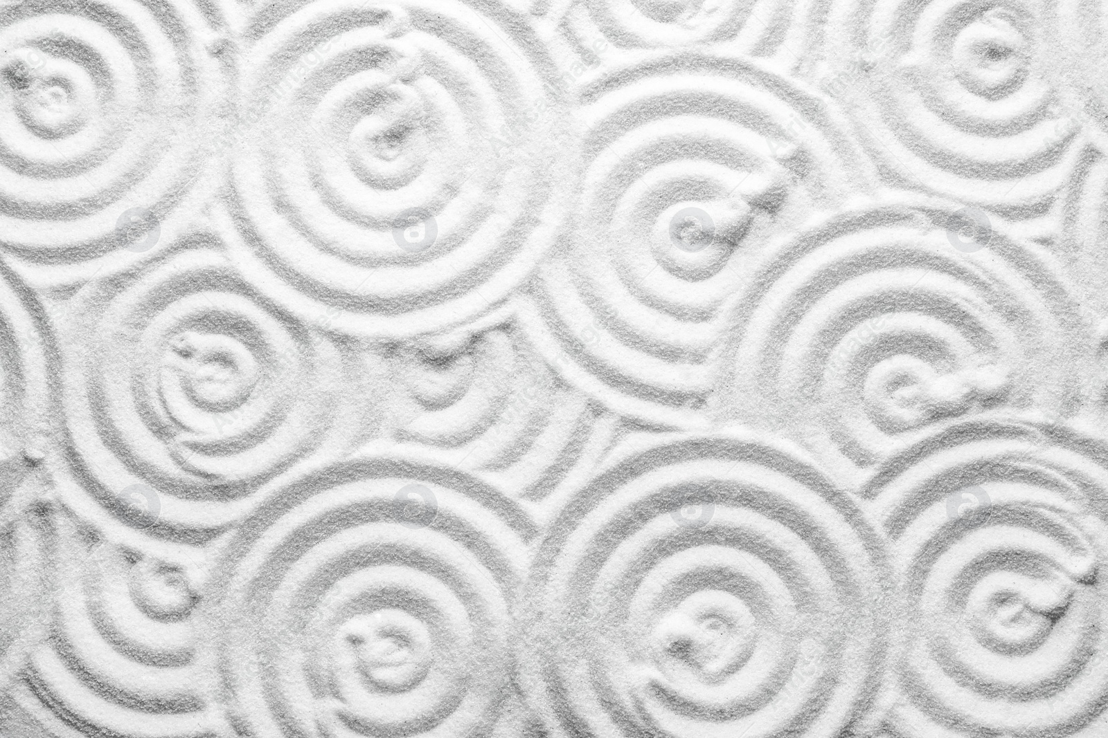 Photo of White sand with pattern as background, top view. Zen, meditation, harmony