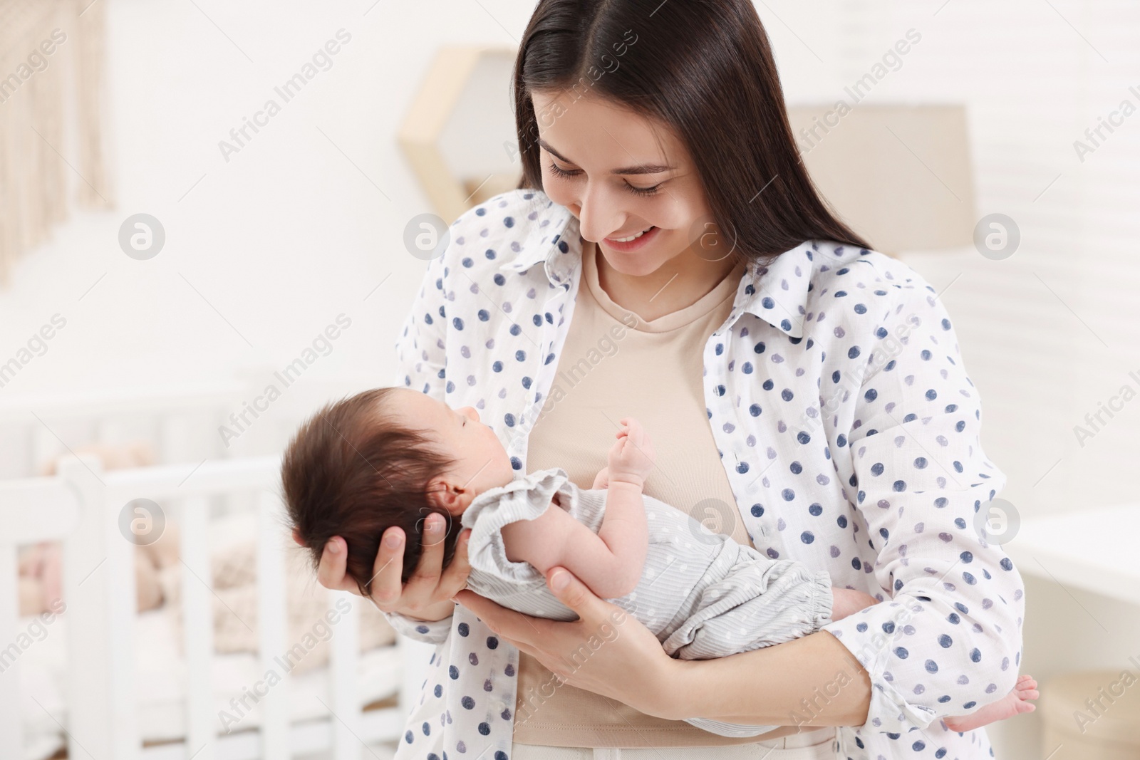 Photo of Mother with her sleeping newborn baby at home