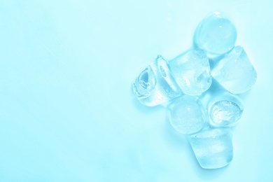 Melting ice cubes on color background, top view. Space for text