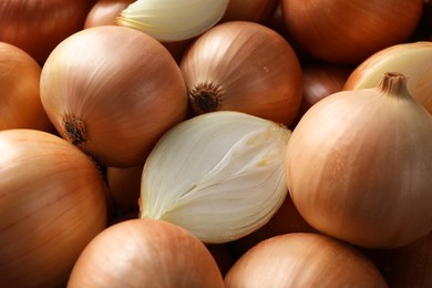 Whole and cut onions as background, closeup