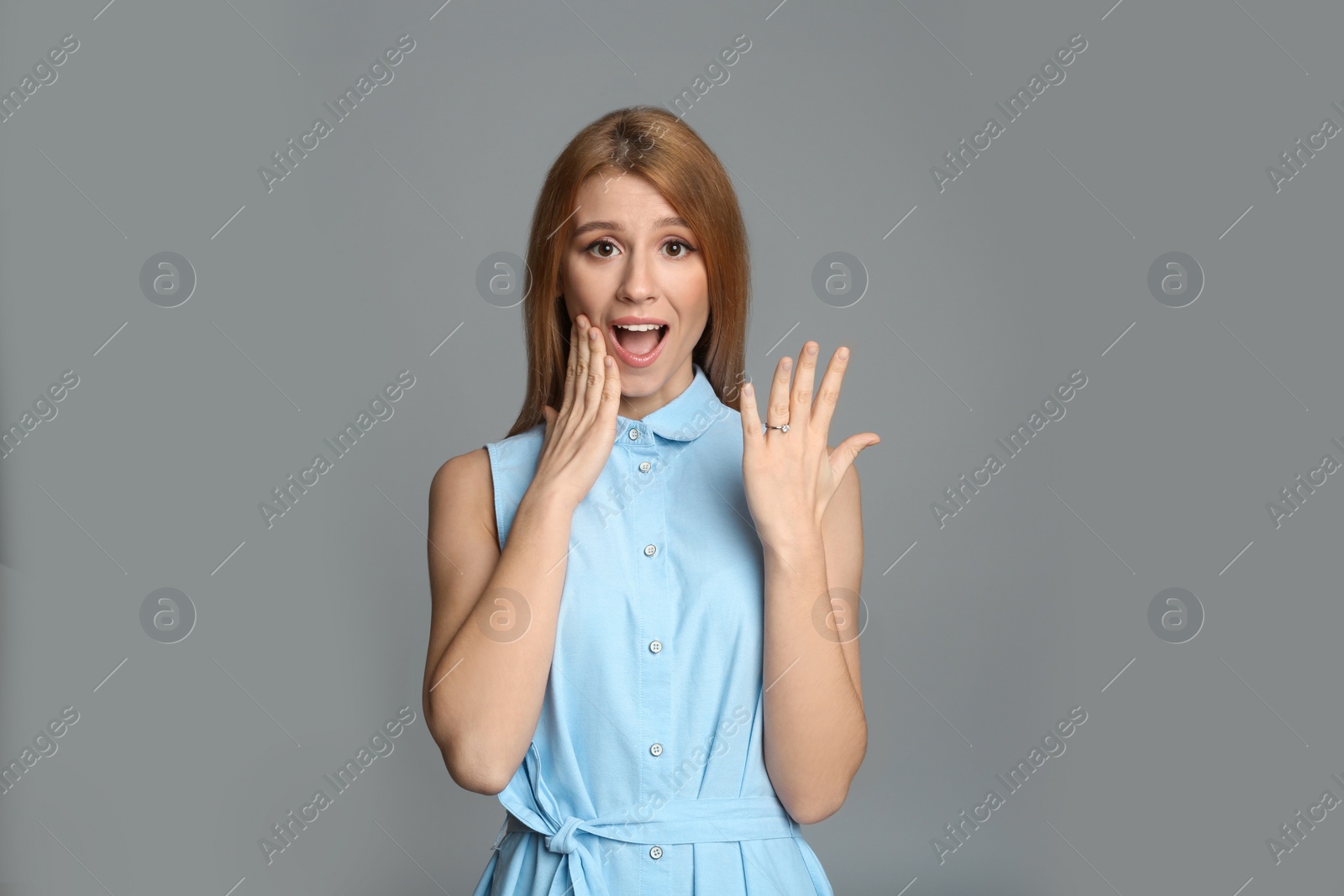 Photo of Excited woman with engagement ring on light grey background