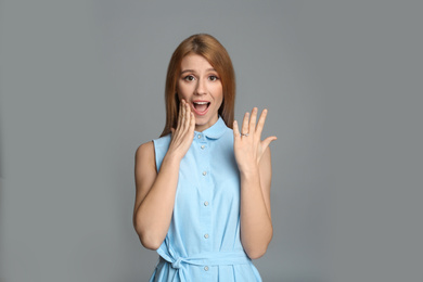 Photo of Excited woman with engagement ring on light grey background