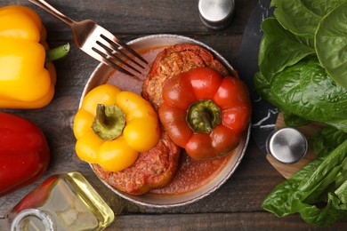 Photo of Delicious stuffed bell peppers served on wooden table, flat lay