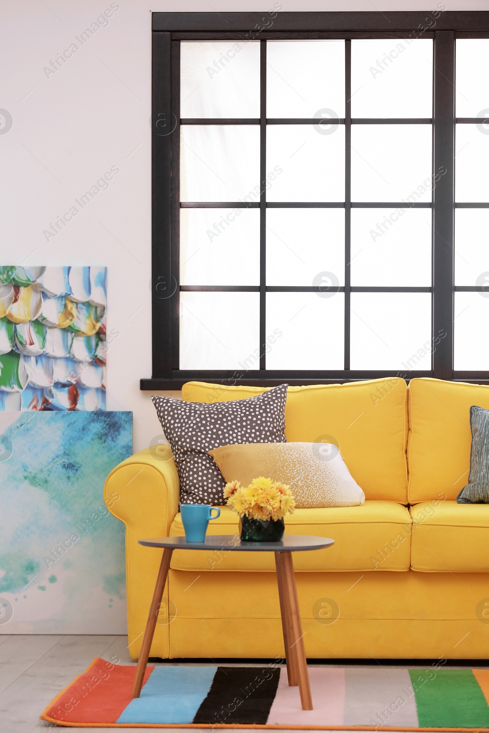 Photo of Modern room interior with comfortable sofa and rainbow carpet