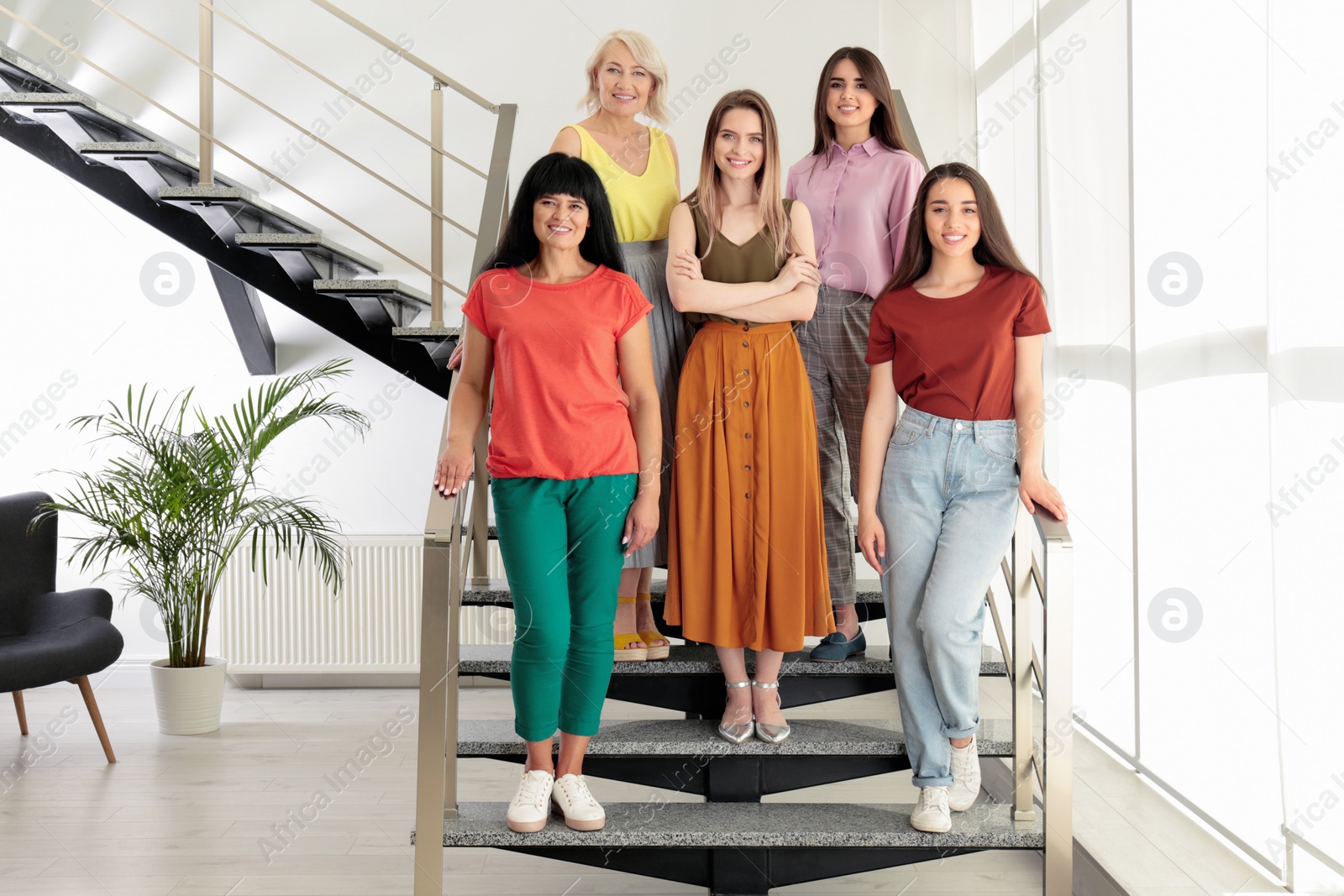 Photo of Group of ladies on stairs indoors. Women power