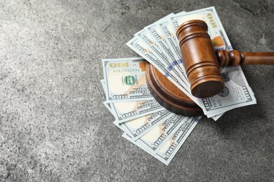 Photo of Judge's gavel and money on grey table. Space for text