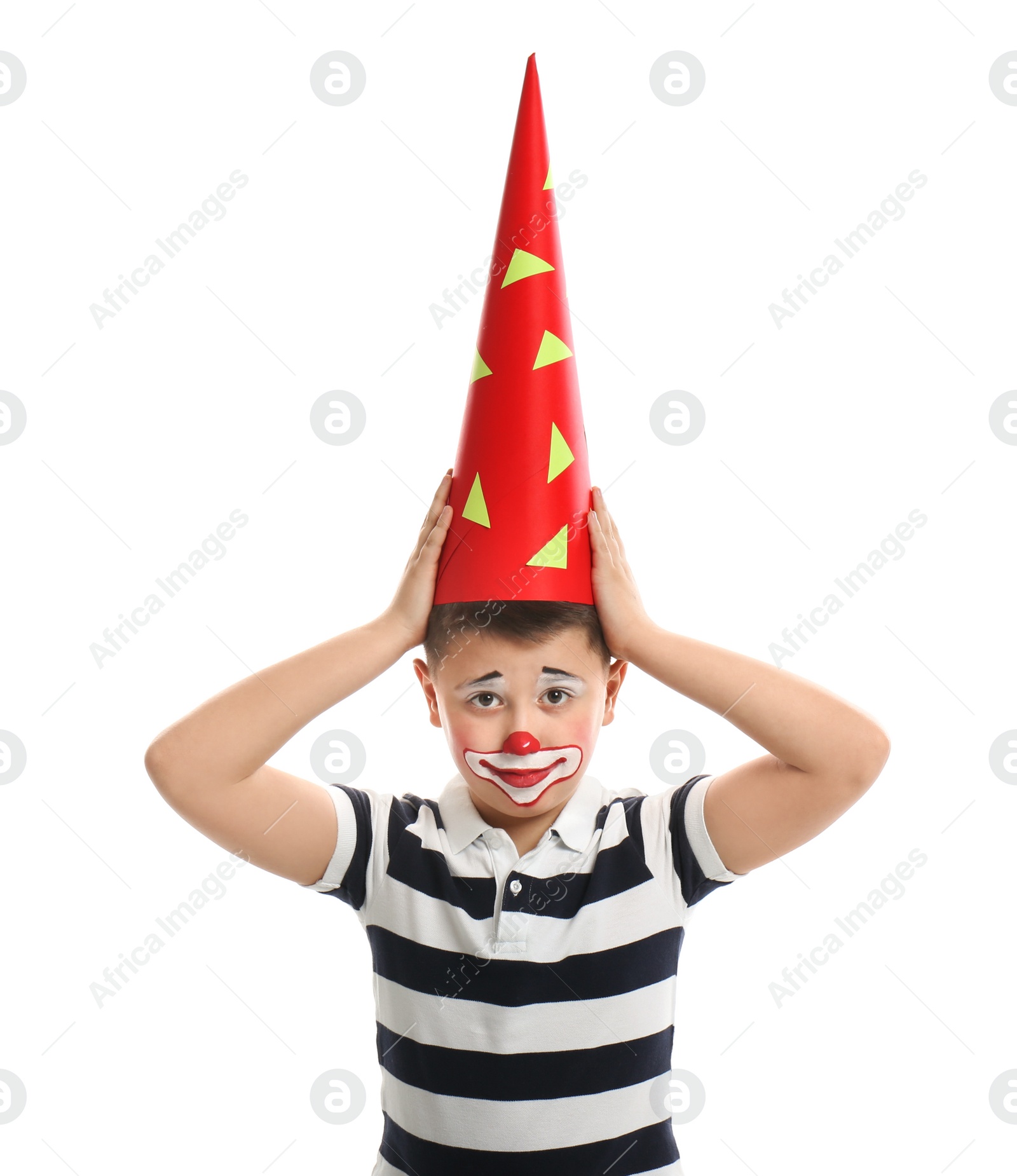 Photo of Preteen boy with clown makeup and party hat on white background. April fool's day