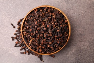 Photo of Aromatic cloves in bowl on brown table, top view
