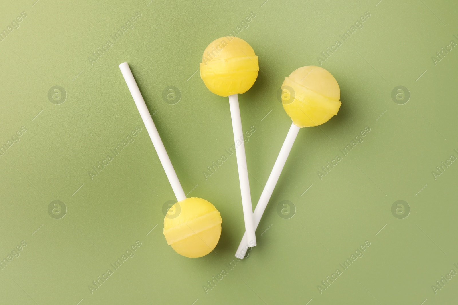 Photo of Tasty lollipops on green background, flat lay