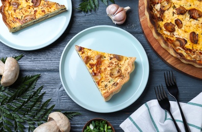 Photo of Delicious pie with mushrooms and cheese served on grey wooden table, flat lay