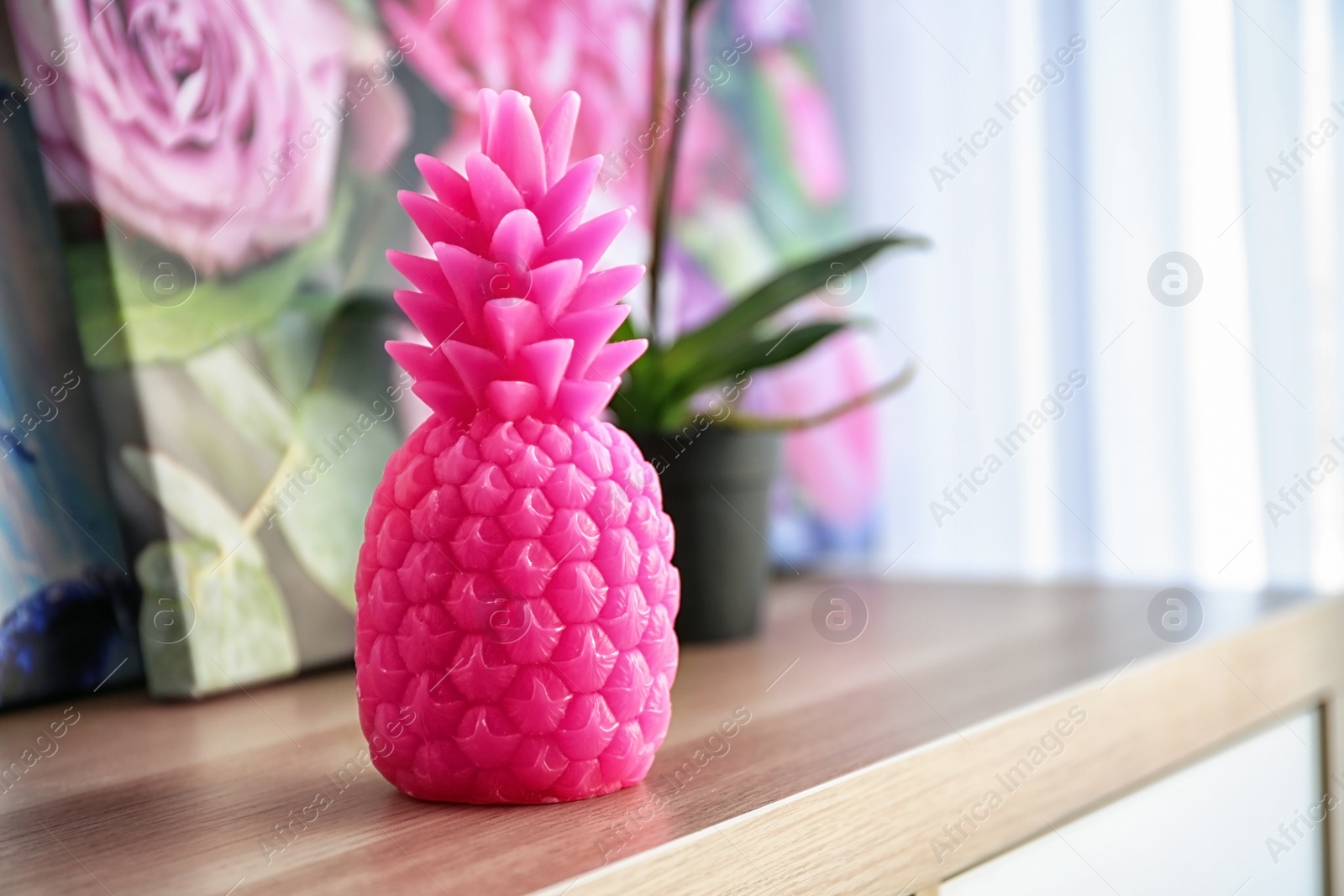 Photo of Pineapple shaped candle on table in room