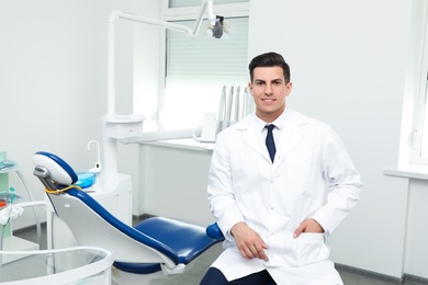 Portrait of professional male dentist in clinic. Space for text