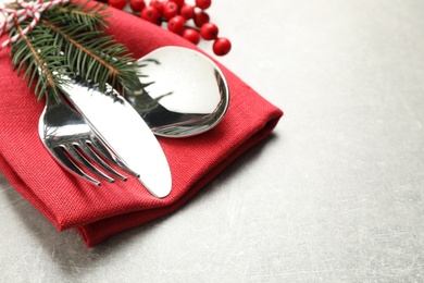 Cutlery set and festive decor on light grey table, closeup. Christmas celebration