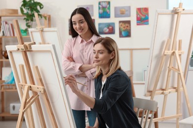 Artist teaching her student to paint in studio. Creative hobby