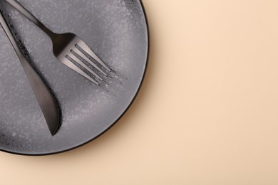 Photo of Setting with stylish cutlery on beige table, top view. Space for text