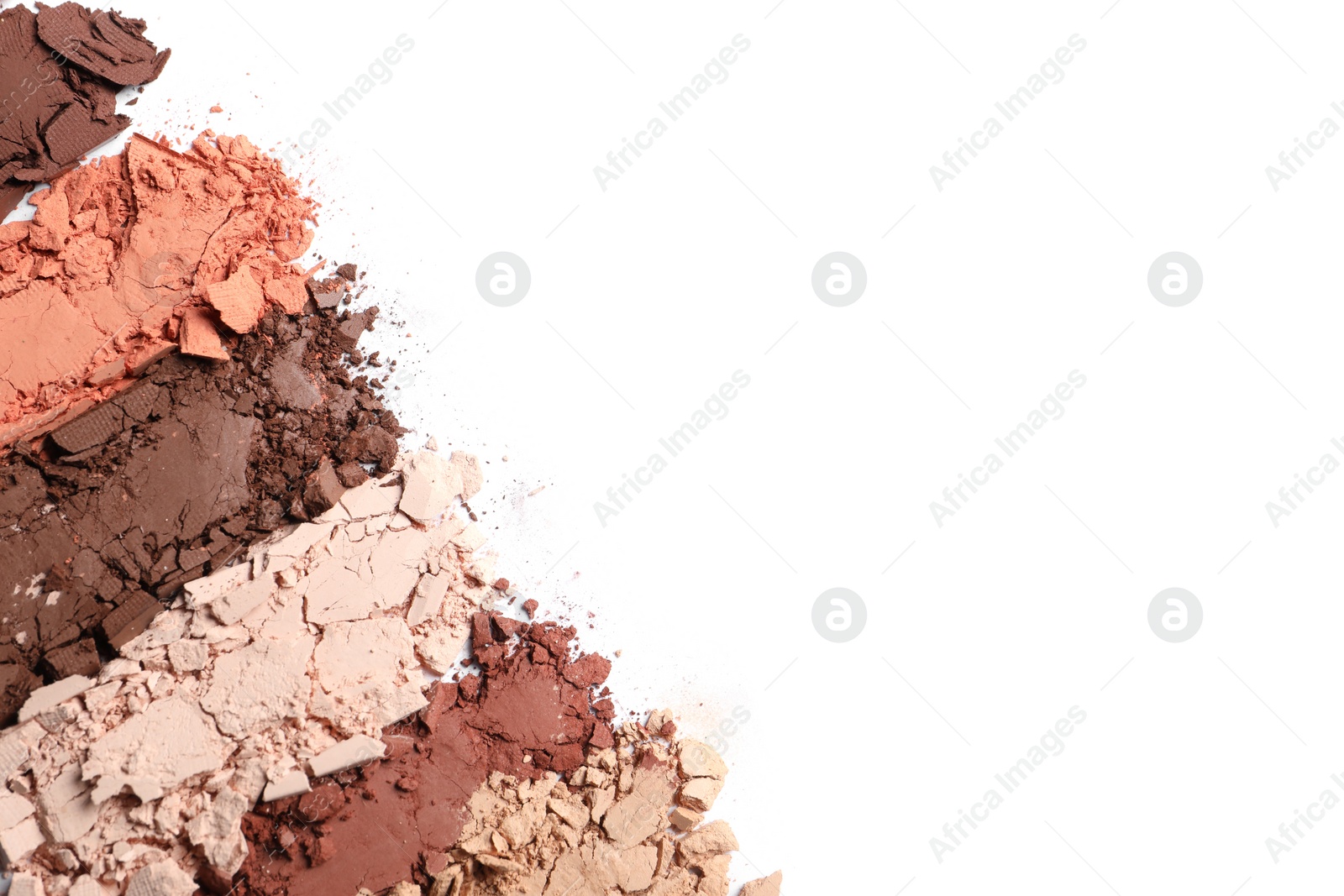 Photo of Swatches of crushed eye shadows on white background, top view. Space for text