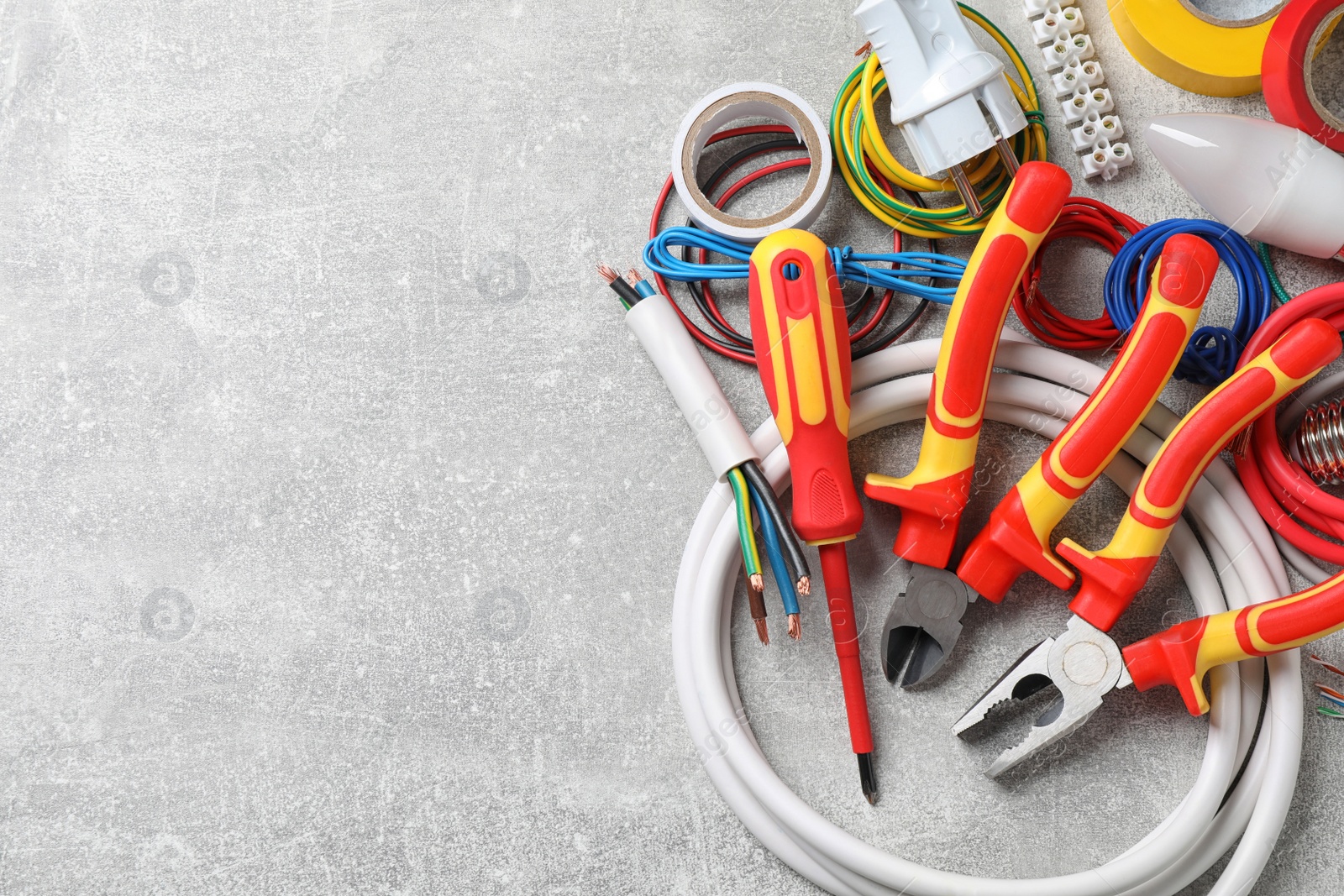 Photo of Set of electrician's tools and accessories on grey background, space for text
