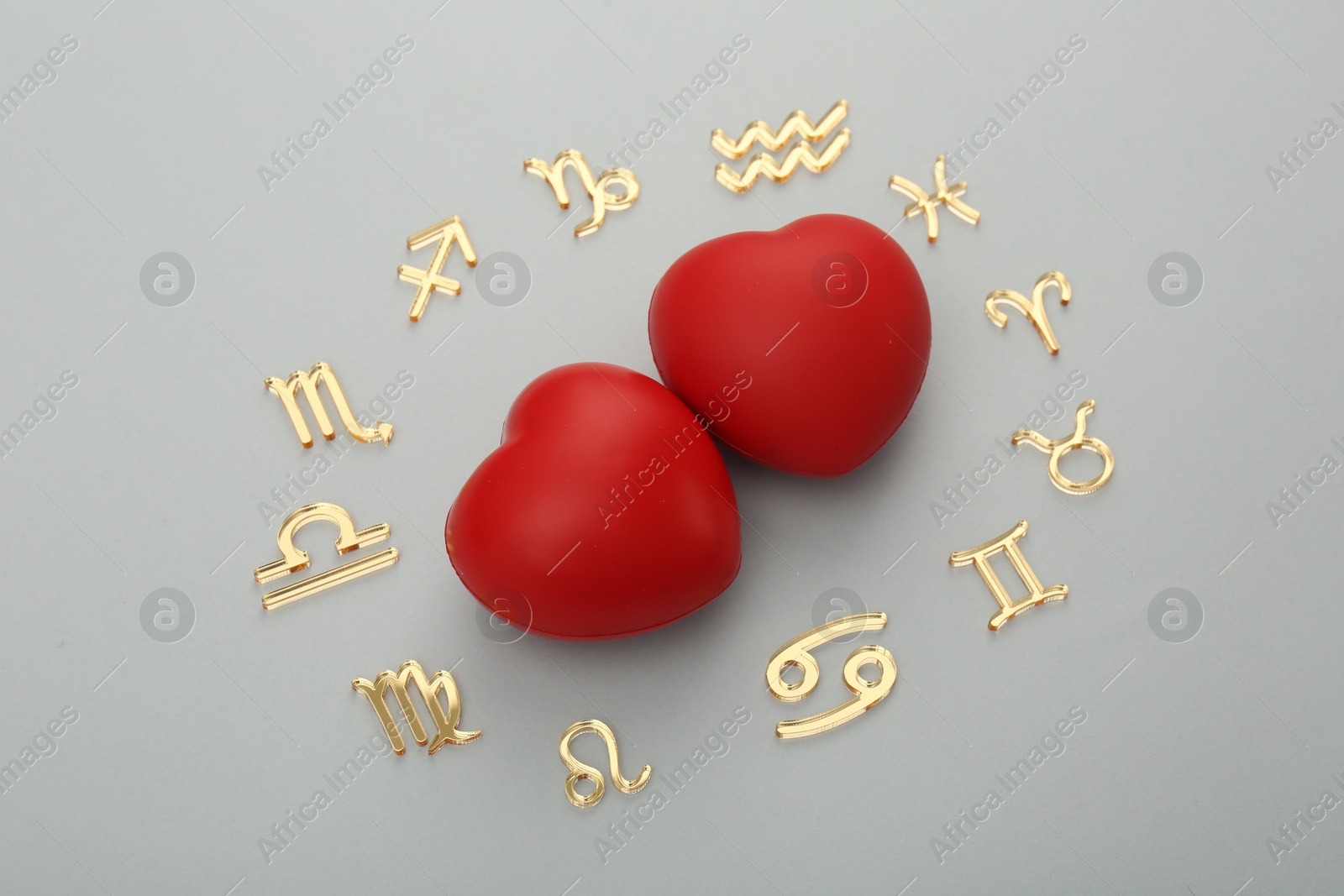 Photo of Zodiac signs and red hearts on grey background, flat lay