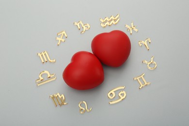 Zodiac signs and red hearts on grey background, flat lay