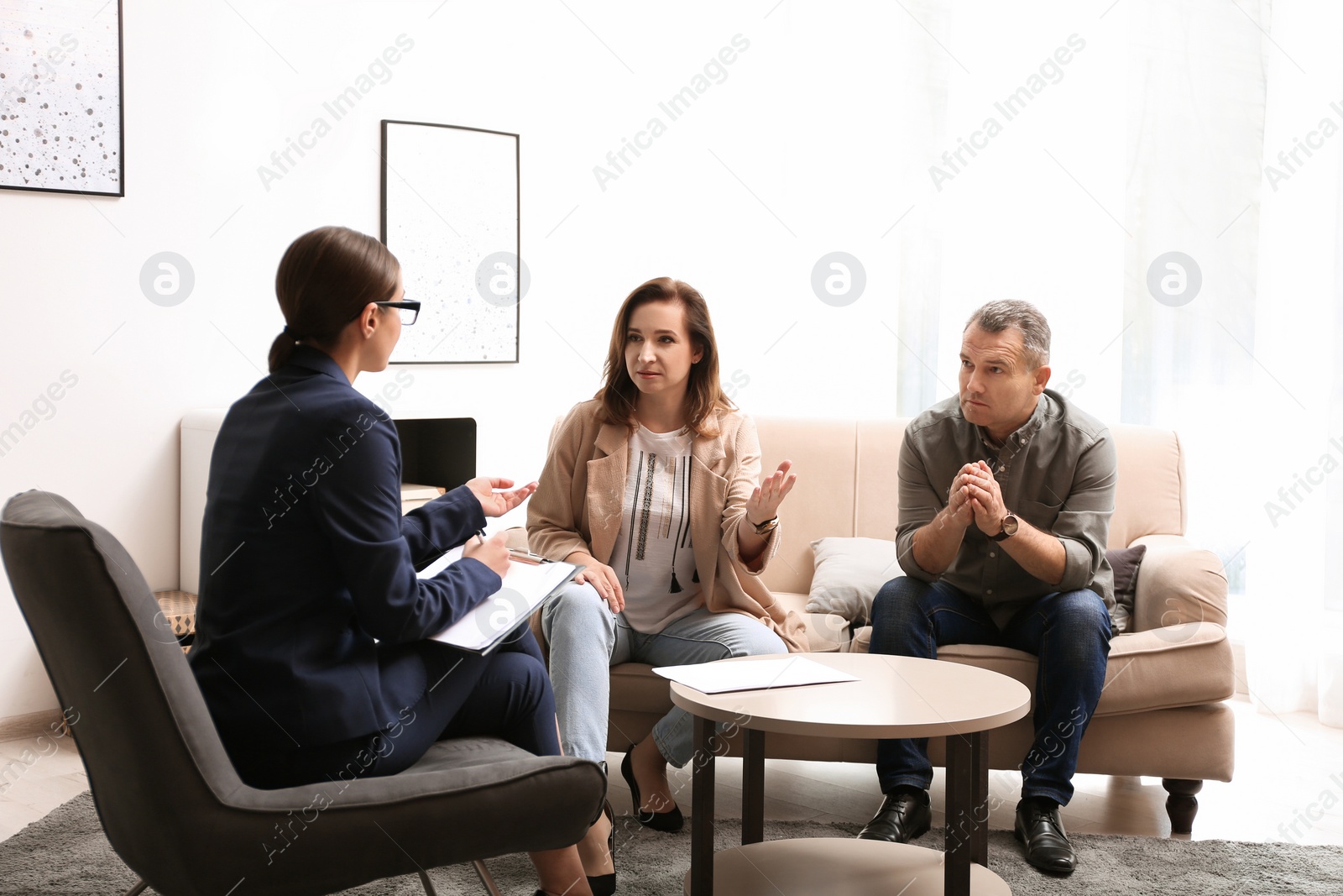 Photo of Psychotherapist working with couple in office. Family counselling