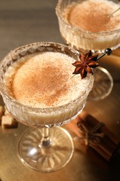 Photo of Delicious eggnog with cinnamon and anise on wooden table
