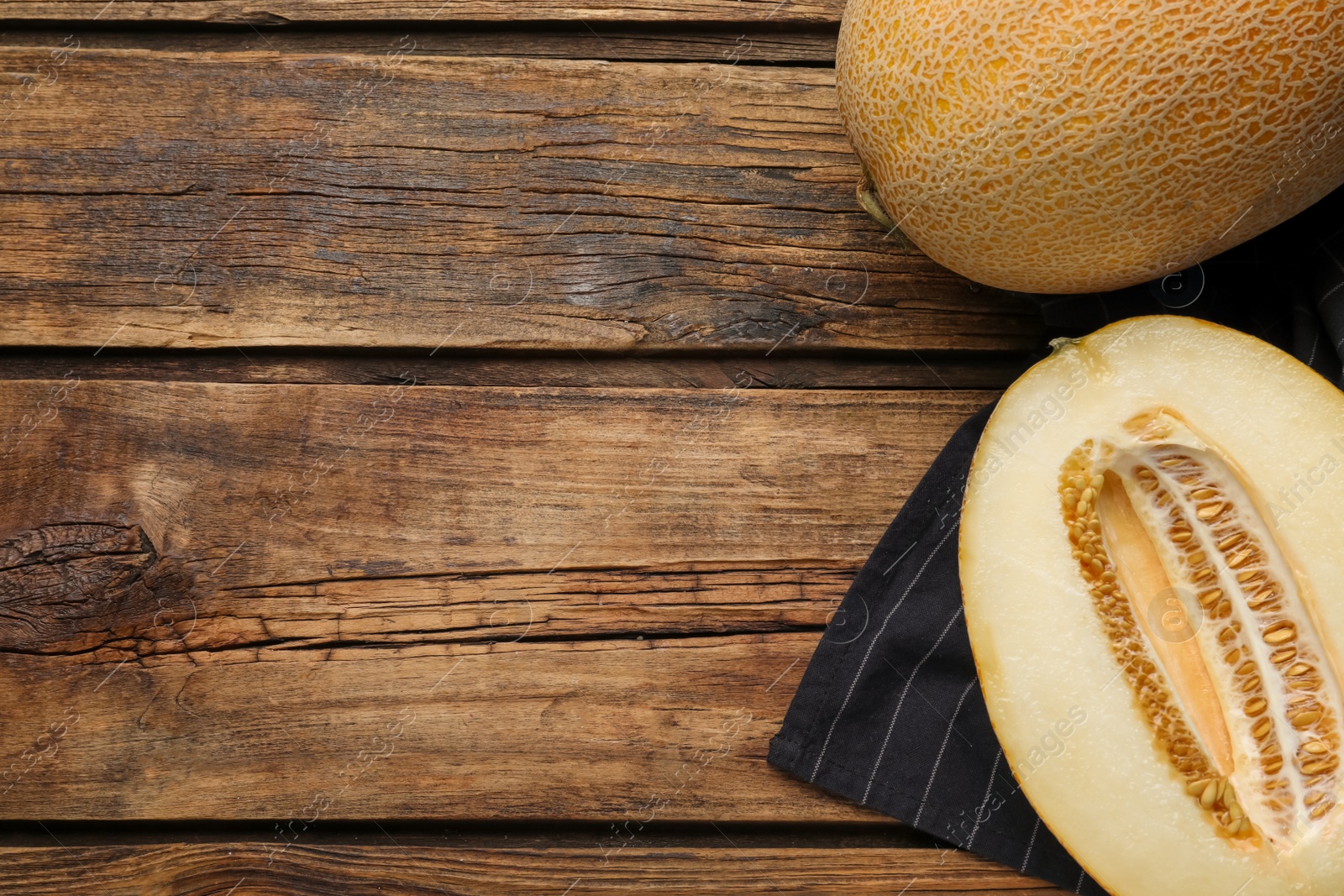 Photo of Delicious honey melon on wooden table, flat lay. Space for text