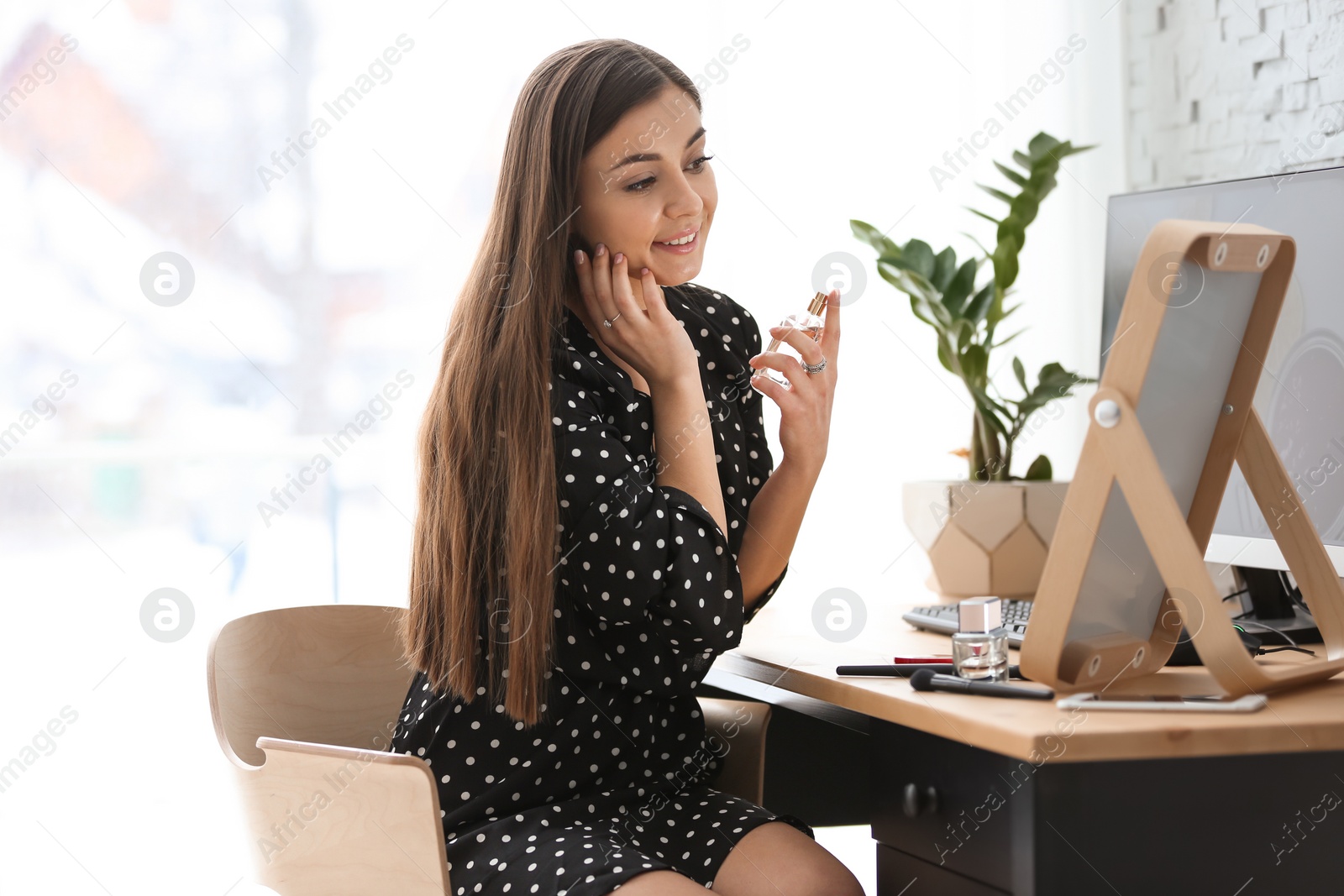 Photo of Young beautiful woman looking in mirror at home