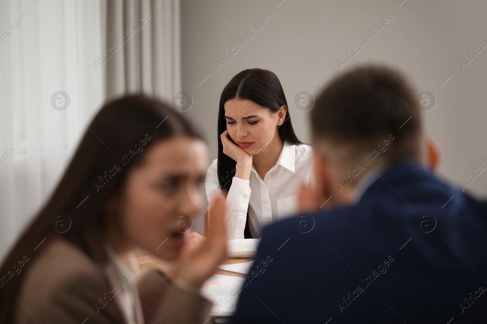 Photo of Coworkers bullying their colleague at workplace in office,