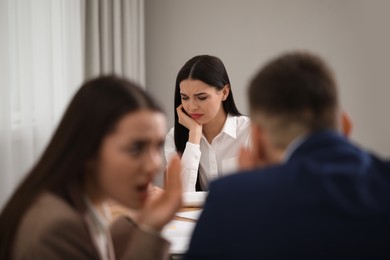 Coworkers bullying their colleague at workplace in office,