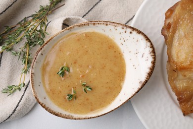 Photo of Delicious turkey gravy and thyme on white table, top view