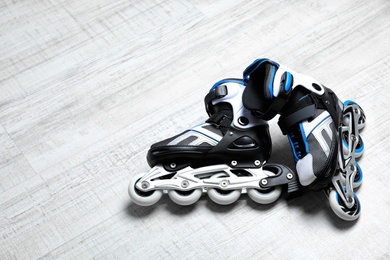 Photo of Inline roller skates on floor indoors. Space for text