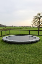 Photo of Spacious backyard with trampoline and wooden fence in evening