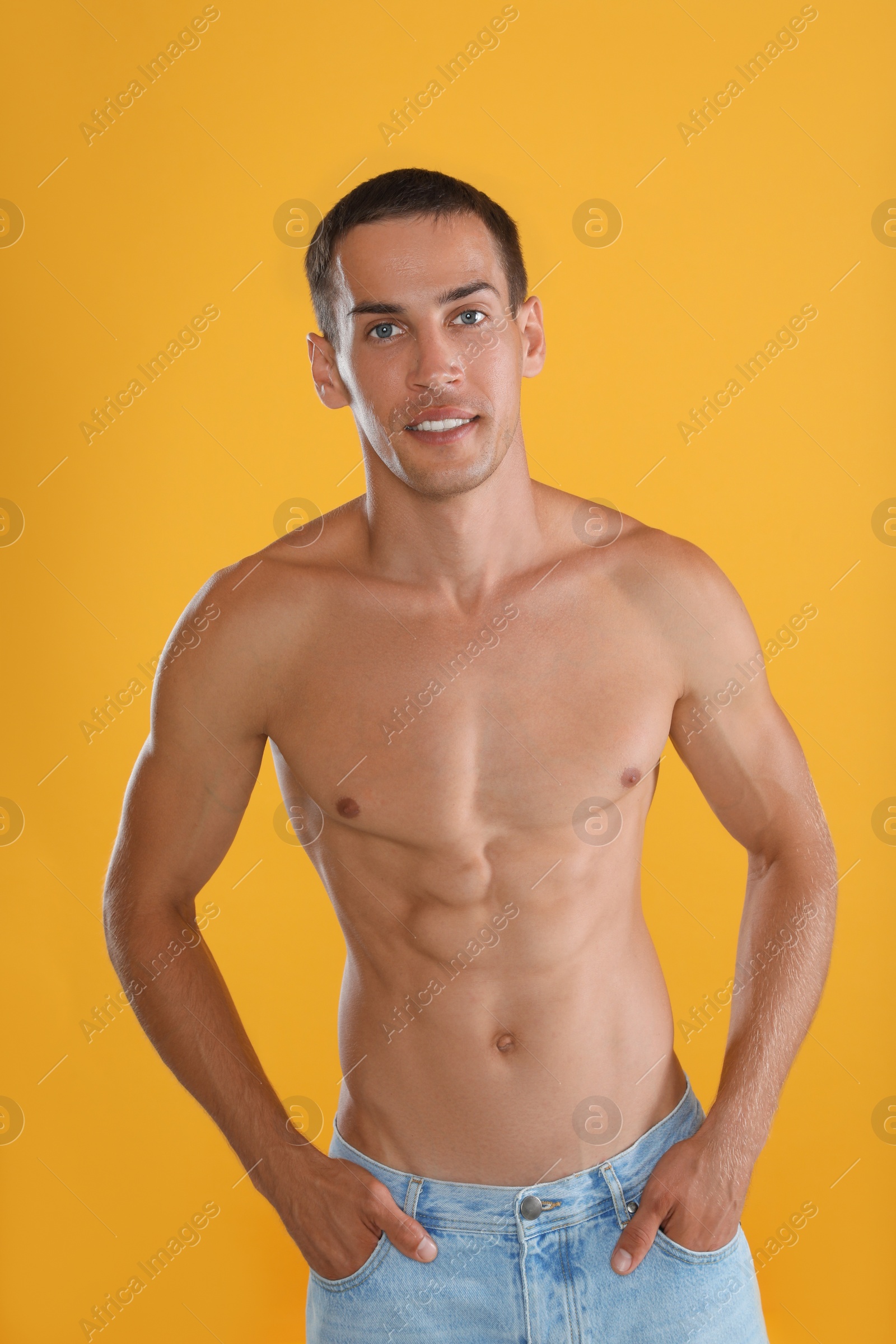 Photo of Handsome shirtless man with slim body on yellow background