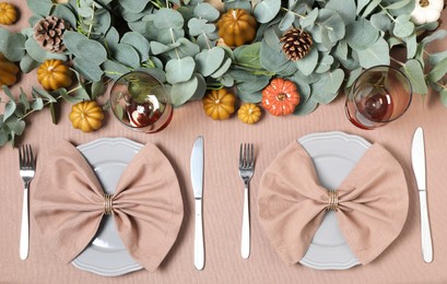 Photo of Autumn table setting with eucalyptus branches and pumpkins, flat lay