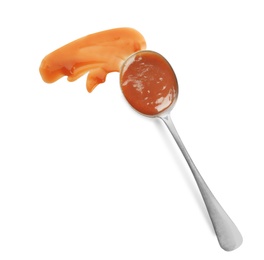 Spoon and strokes of caramel sauce isolated on white, top view