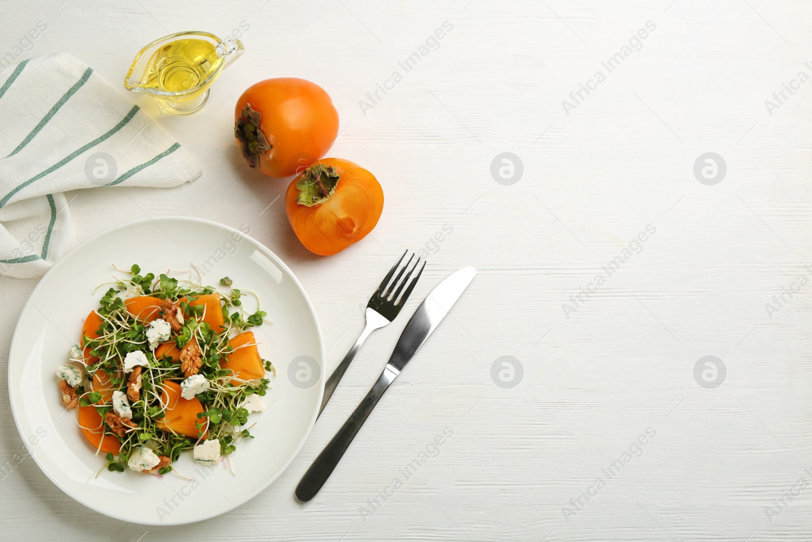 Photo of Delicious persimmon salad served on white wooden table, flat lay. Space for text