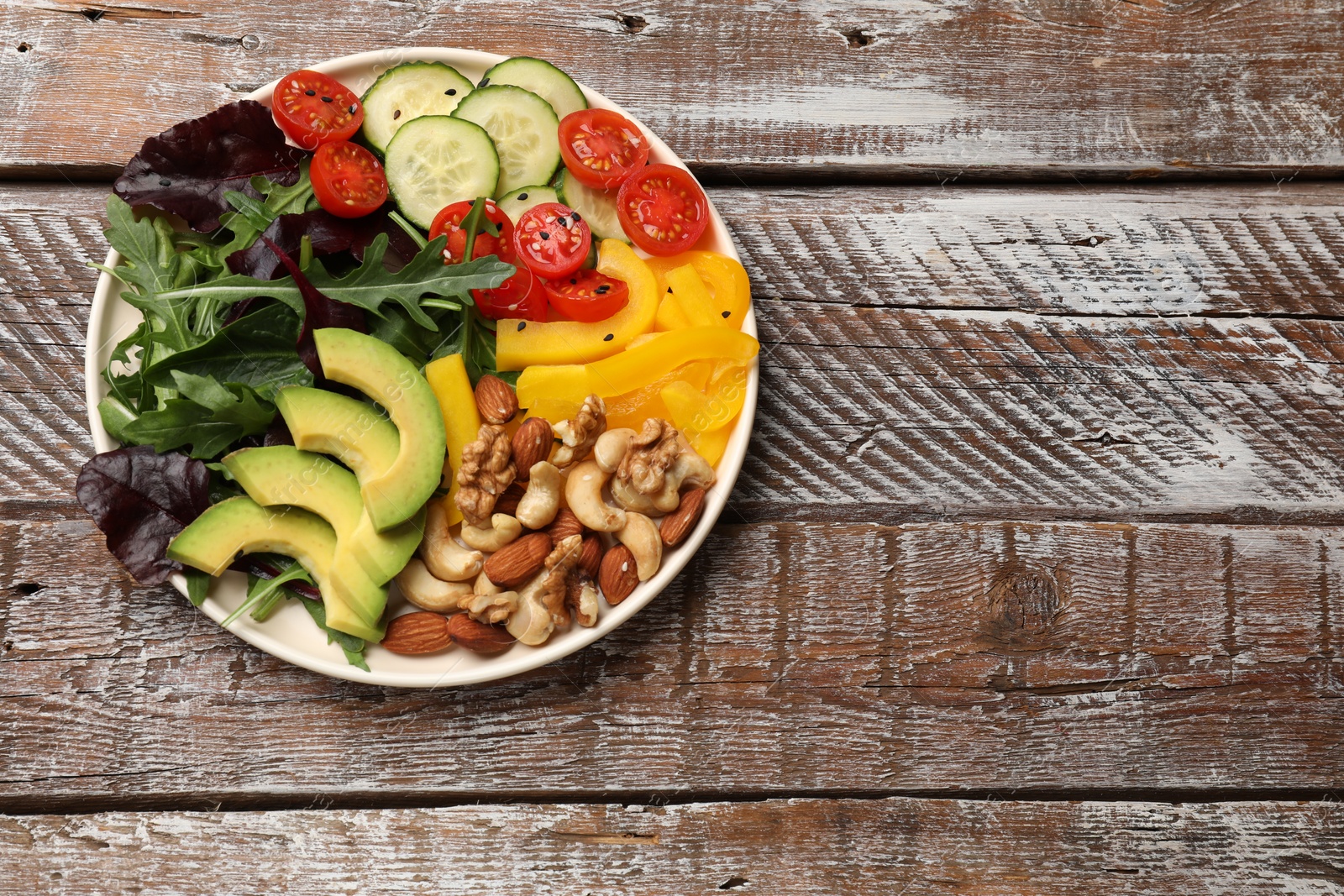 Photo of Balanced diet and vegetarian foods. Plate with different delicious products on wooden table, top view. Space for text