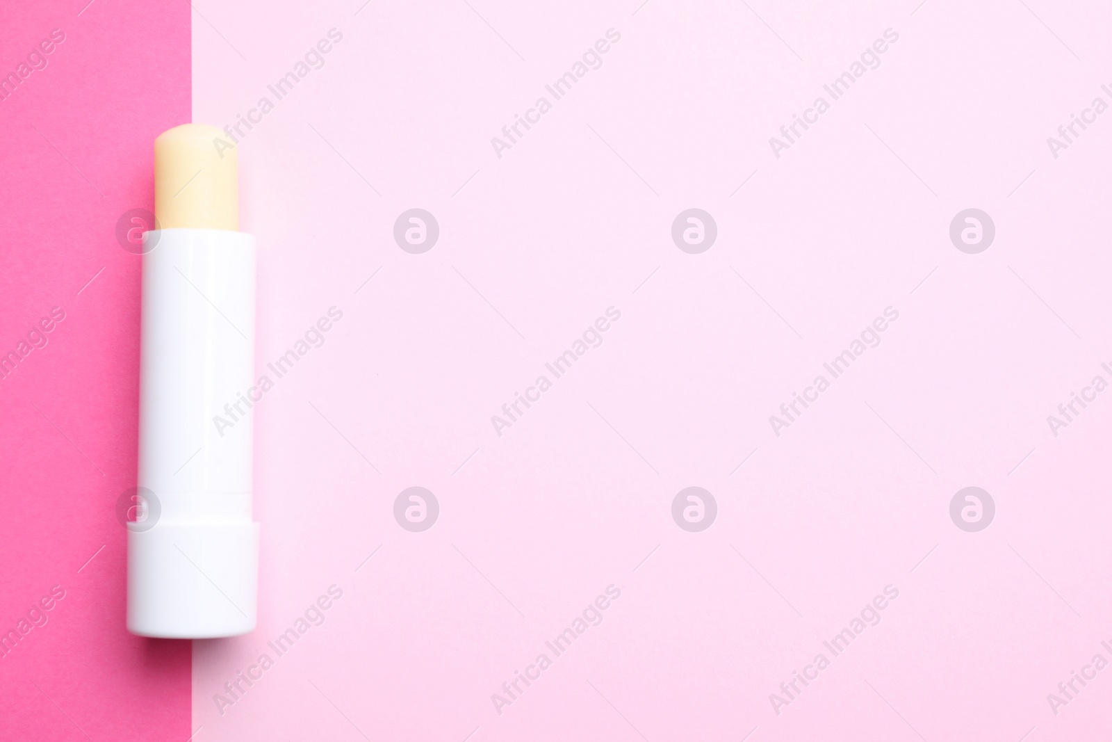 Photo of Hygienic lipstick on color background, top view. Space for text