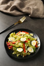 Photo of Delicious salad with Chinese cabbage and quail eggs served on black table